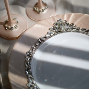 Close-up detail of Grace Classic rose gold plate with dimensional crystal floral border and champagne flute bases embellished with clear crystals