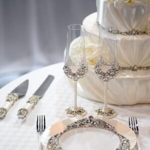 Complete Ethereal collection wedding set with crystal champagne flutes, dinner plate, cake cutting set, and tiered wedding cake